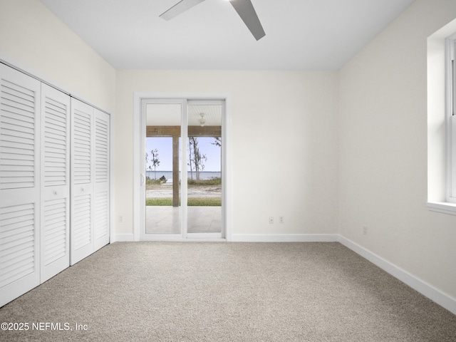 unfurnished bedroom with multiple windows, carpet floors, and ceiling fan