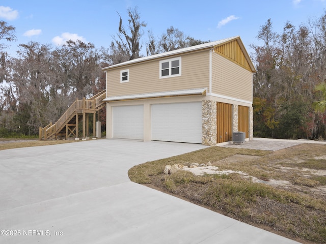 view of property exterior with central AC unit and a garage