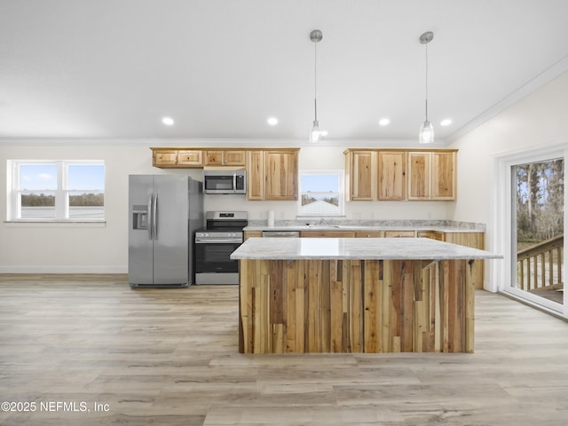 kitchen featuring a wealth of natural light, decorative light fixtures, a center island, stainless steel appliances, and crown molding