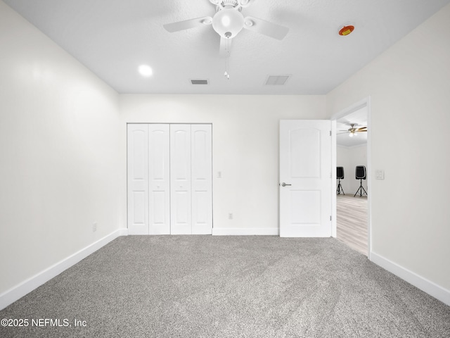 unfurnished bedroom with light colored carpet, ceiling fan, and a closet