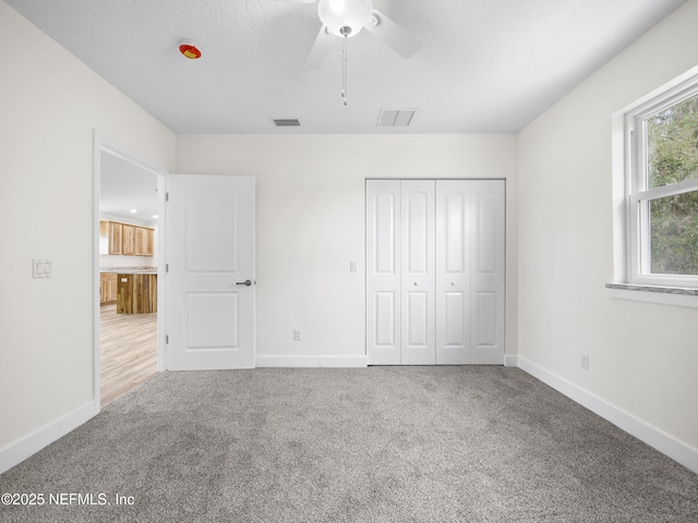 unfurnished bedroom with carpet flooring, ceiling fan, and a closet