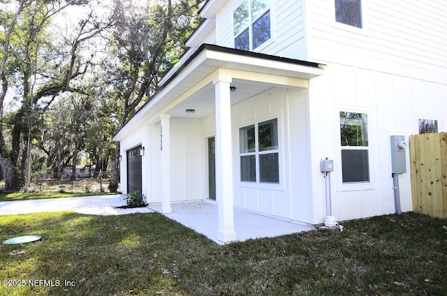 entrance to property featuring a garage and a lawn