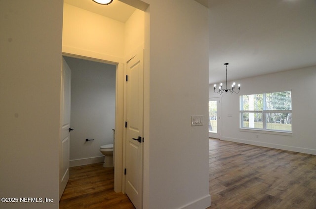 corridor featuring a chandelier and dark hardwood / wood-style floors