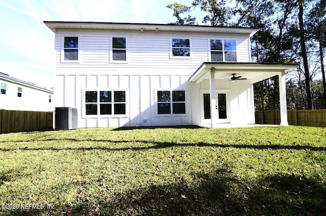 back of property with central AC unit, a lawn, and ceiling fan