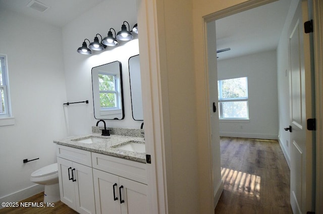 bathroom with hardwood / wood-style floors, toilet, and vanity