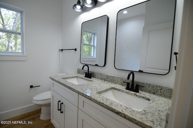 bathroom with hardwood / wood-style flooring, toilet, and vanity