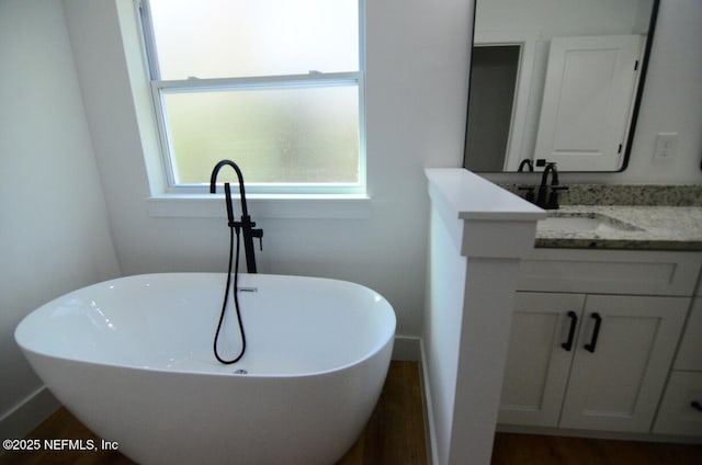 bathroom featuring a tub to relax in and vanity