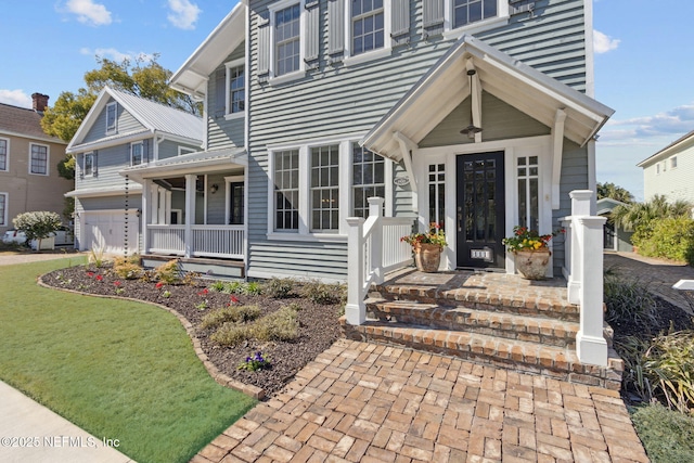 view of front of home featuring a garage, a front lawn, and covered porch