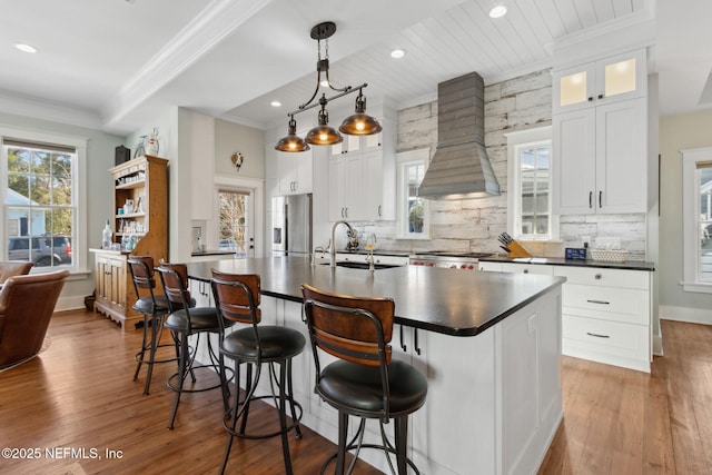 kitchen featuring white cabinetry, sink, stainless steel fridge with ice dispenser, and premium range hood