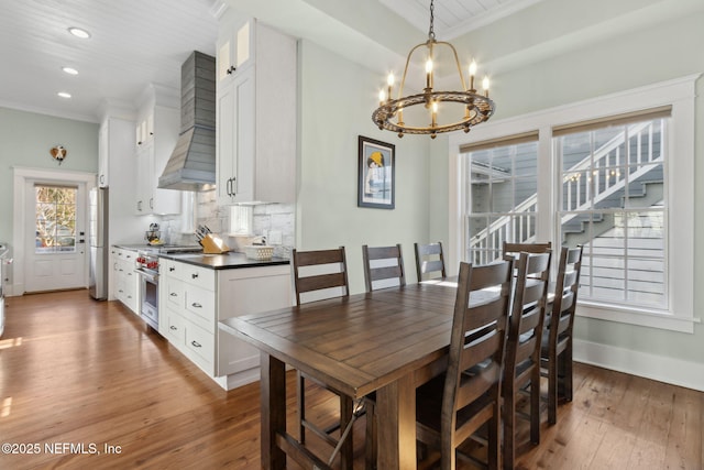 dining space featuring ornamental molding, a notable chandelier, and dark hardwood / wood-style flooring