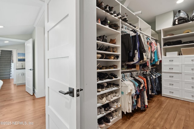 walk in closet with light hardwood / wood-style floors