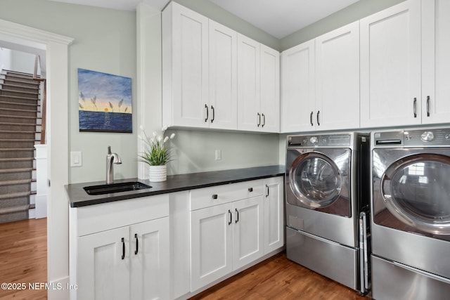 laundry room with dark hardwood / wood-style flooring, sink, cabinets, and independent washer and dryer