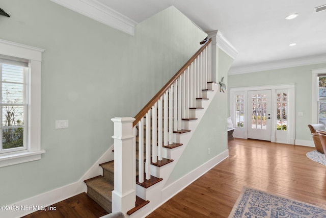 staircase with ornamental molding and wood-type flooring