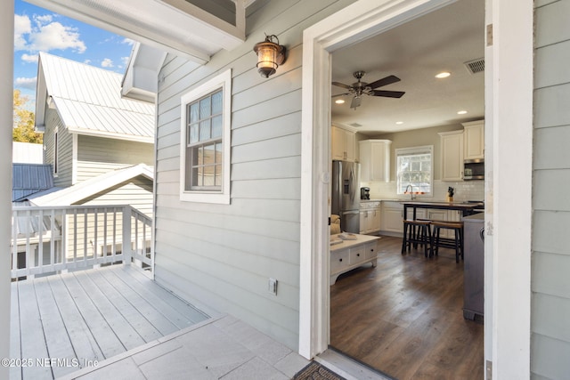 wooden deck with sink and ceiling fan