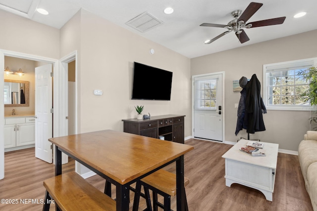 living room with sink, light hardwood / wood-style floors, and ceiling fan