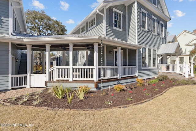 view of front facade with ceiling fan, covered porch, and a front lawn