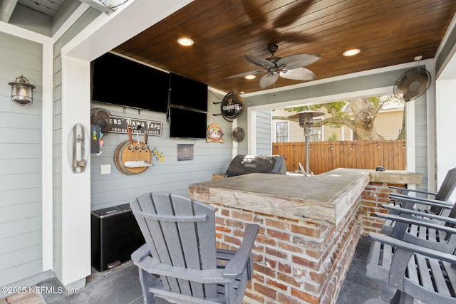 view of patio featuring ceiling fan, exterior bar, and area for grilling