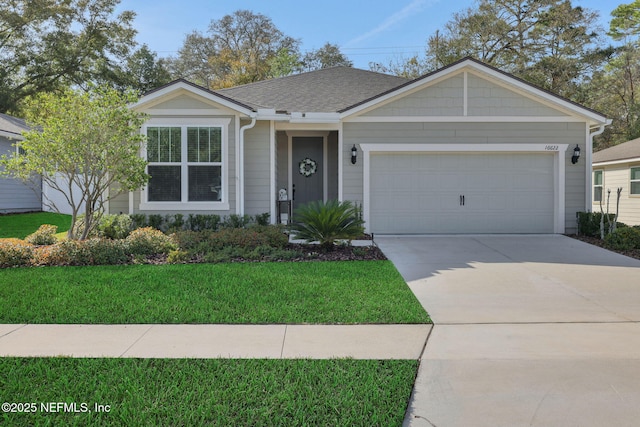 ranch-style house featuring a garage, a front lawn, concrete driveway, and roof with shingles