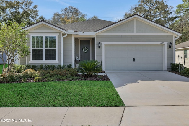 ranch-style house featuring driveway, a shingled roof, a garage, and a front yard