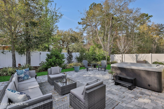 view of patio / terrace featuring a hot tub, a fenced backyard, and an outdoor hangout area