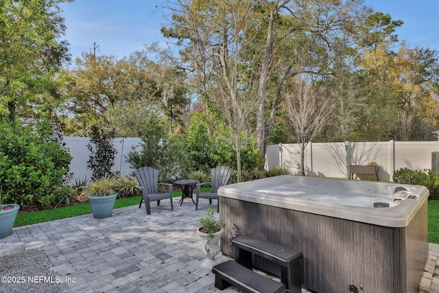 view of patio featuring a fenced backyard and a hot tub