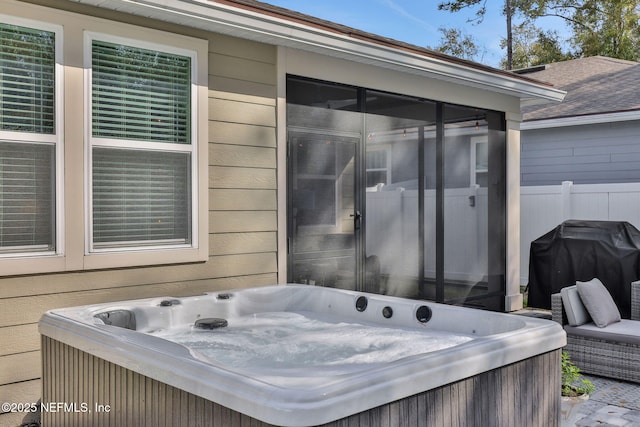 view of patio / terrace with a sunroom, a hot tub, fence, and area for grilling