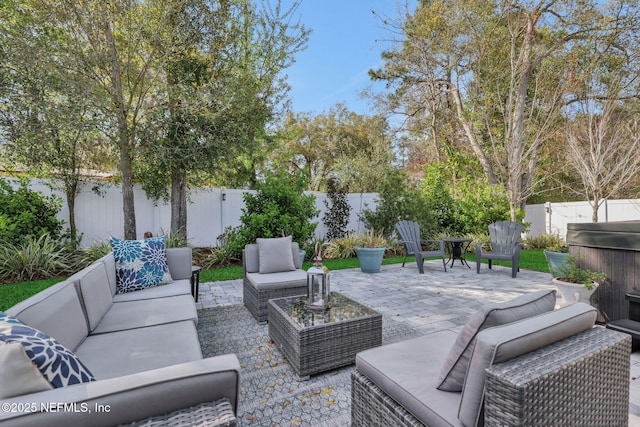 view of patio with a fenced backyard, a hot tub, and an outdoor hangout area