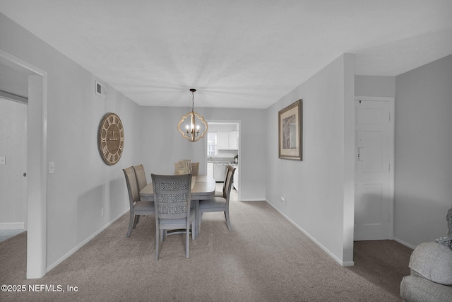 carpeted dining space with a textured ceiling and a chandelier