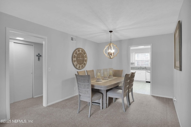 carpeted dining area featuring a notable chandelier and a textured ceiling