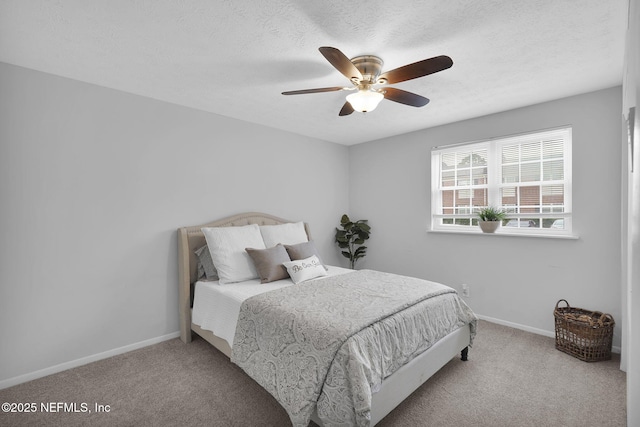 carpeted bedroom with ceiling fan and a textured ceiling