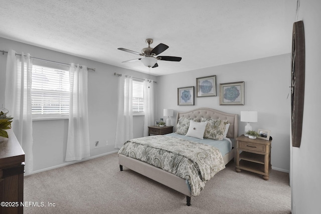 carpeted bedroom featuring ceiling fan and a textured ceiling