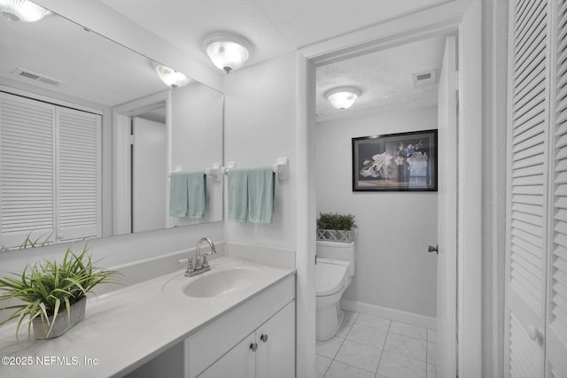 bathroom with tile patterned floors, vanity, toilet, and a textured ceiling