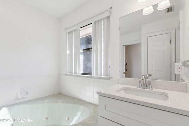 bathroom featuring vanity and a washtub