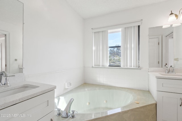 bathroom featuring vanity, a bathtub, and a textured ceiling