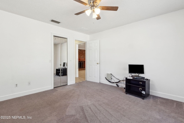 unfurnished bedroom featuring carpet, a textured ceiling, ceiling fan, and a closet