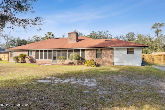 back of house featuring a yard, a sunroom, and central air condition unit