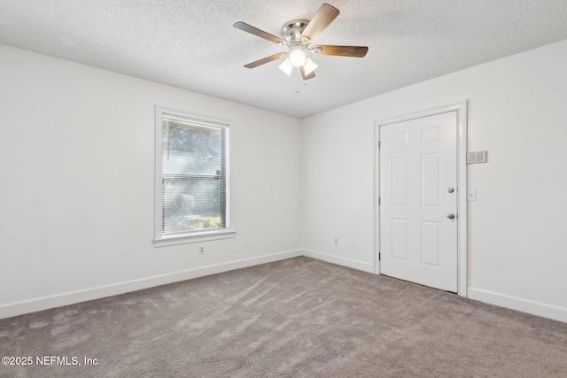 carpeted spare room featuring ceiling fan and a textured ceiling