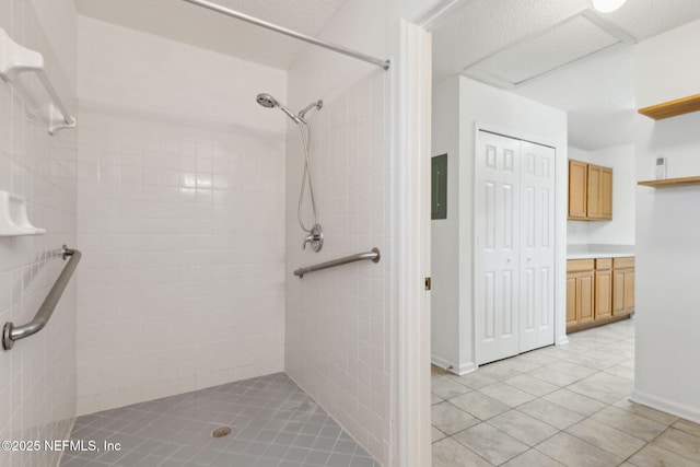 bathroom featuring tiled shower and tile patterned flooring