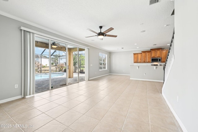 unfurnished living room with crown molding, a textured ceiling, ceiling fan, and light tile patterned flooring