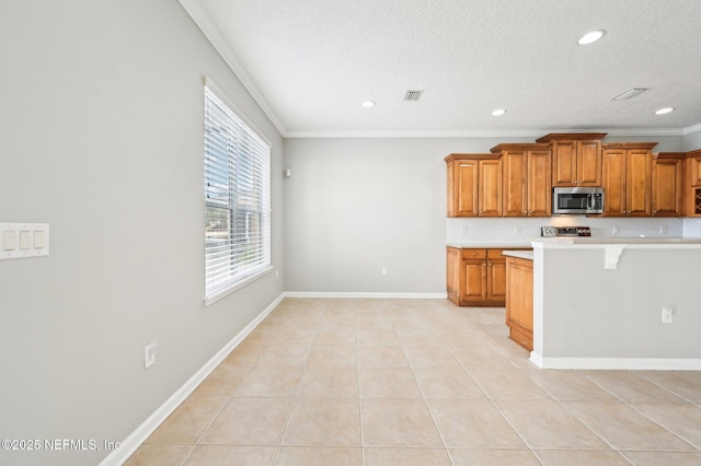 kitchen featuring crown molding, light tile patterned floors, appliances with stainless steel finishes, a kitchen breakfast bar, and decorative backsplash