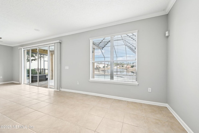 tiled empty room featuring ornamental molding and a textured ceiling