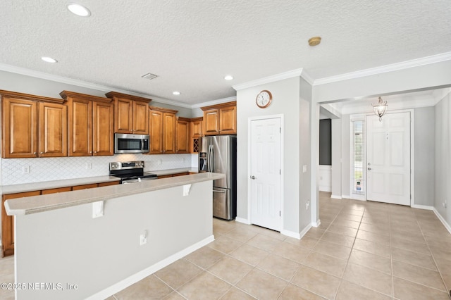 kitchen with tasteful backsplash, crown molding, a center island, and appliances with stainless steel finishes