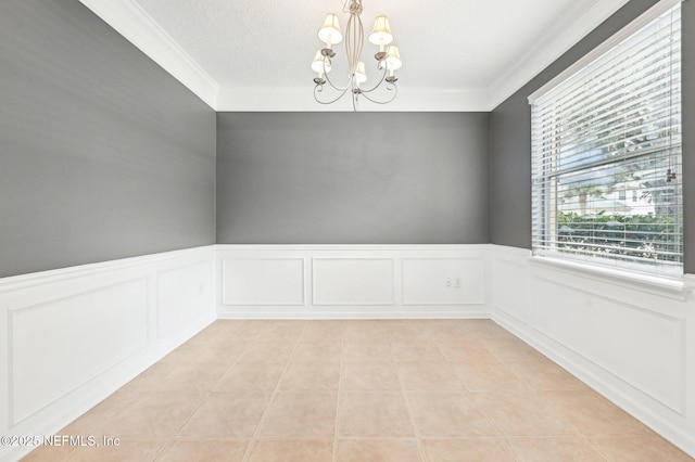 spare room featuring crown molding, a chandelier, and light tile patterned floors