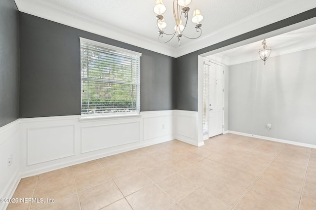 empty room featuring ornamental molding, light tile patterned flooring, and a notable chandelier