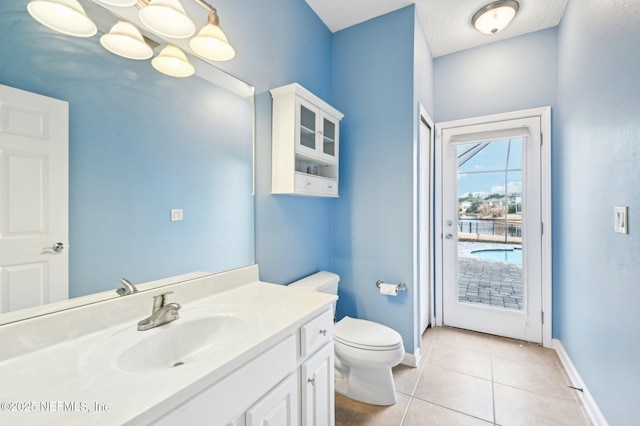 bathroom featuring vanity, tile patterned floors, a chandelier, and toilet