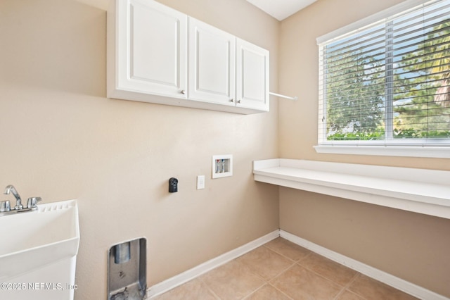 laundry room featuring cabinets, light tile patterned flooring, hookup for a washing machine, and sink