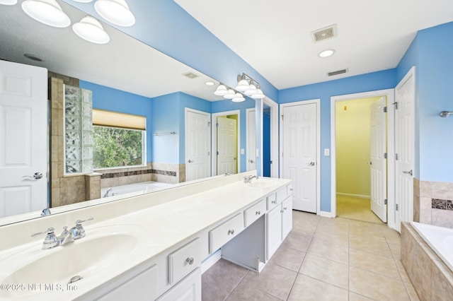 bathroom featuring vanity, tiled bath, and tile patterned floors