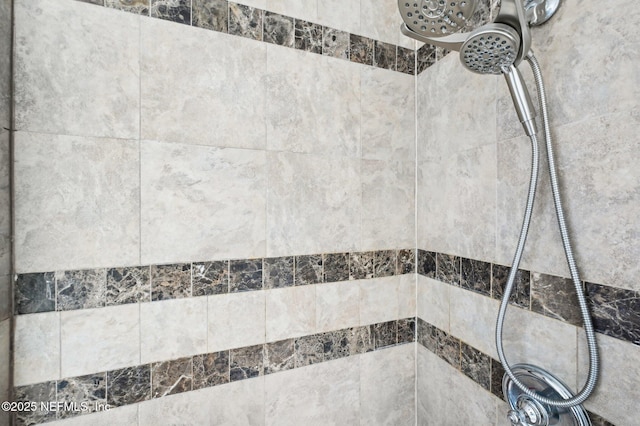 interior details featuring tiled shower