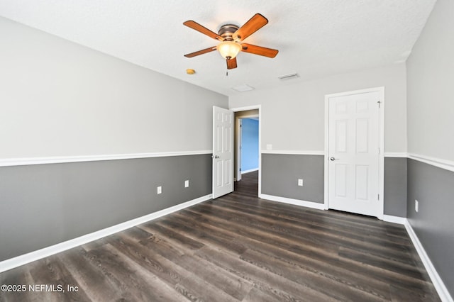 unfurnished bedroom featuring ceiling fan and dark hardwood / wood-style floors