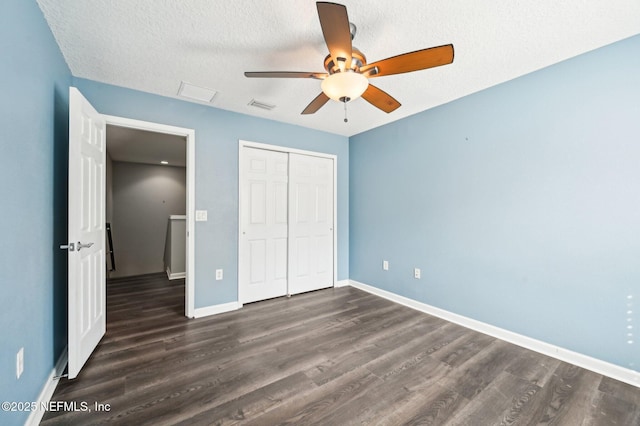 unfurnished bedroom with ceiling fan, dark hardwood / wood-style flooring, a closet, and a textured ceiling